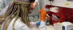 PhD student Parsa Parhady shows an A-level student how to use a pipette.