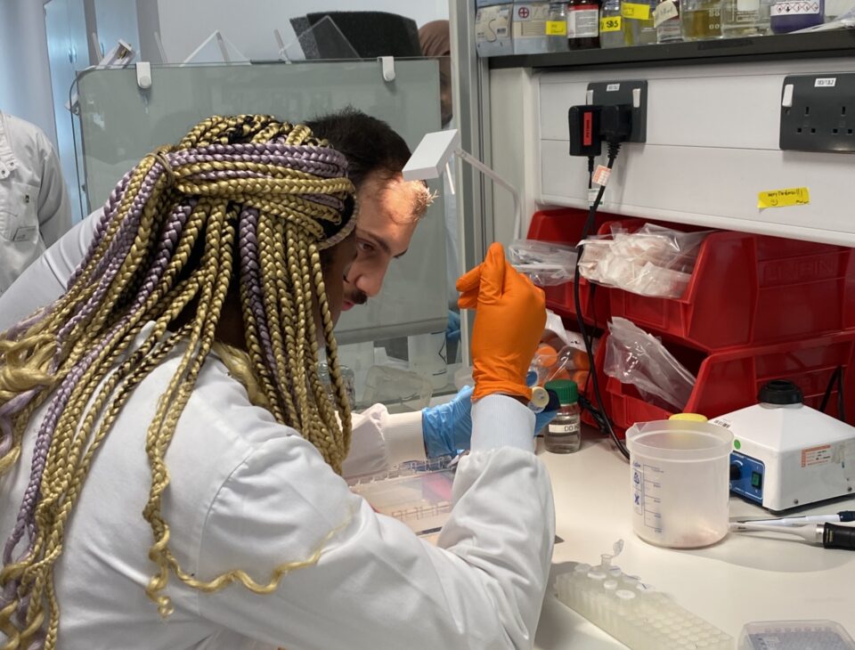 PhD student Parsa Parhady shows an A-level student how to use a pipette.