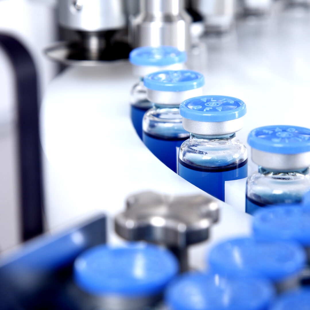 Glass bottles in production in the tray of an automatic liquid dispenser, a line for filling medicines against bacteria and viruses, antibiotics and vaccines